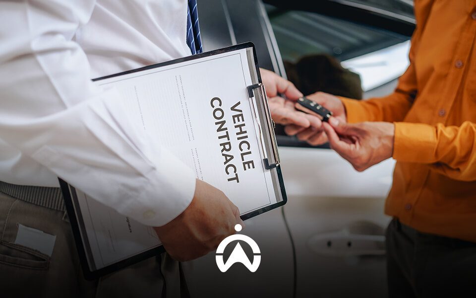 A person in a white shirt holds a vehicle contract while handing car keys to another individual in an orange shirt.