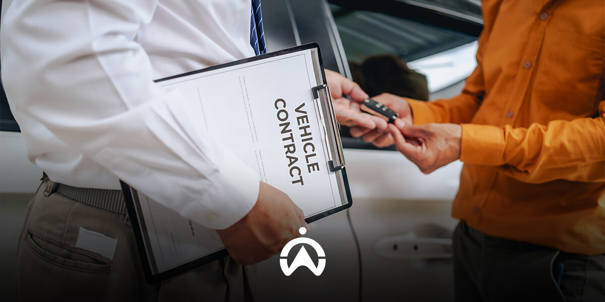 A person in a white shirt holds a vehicle contract while handing car keys to another individual in an orange shirt.
