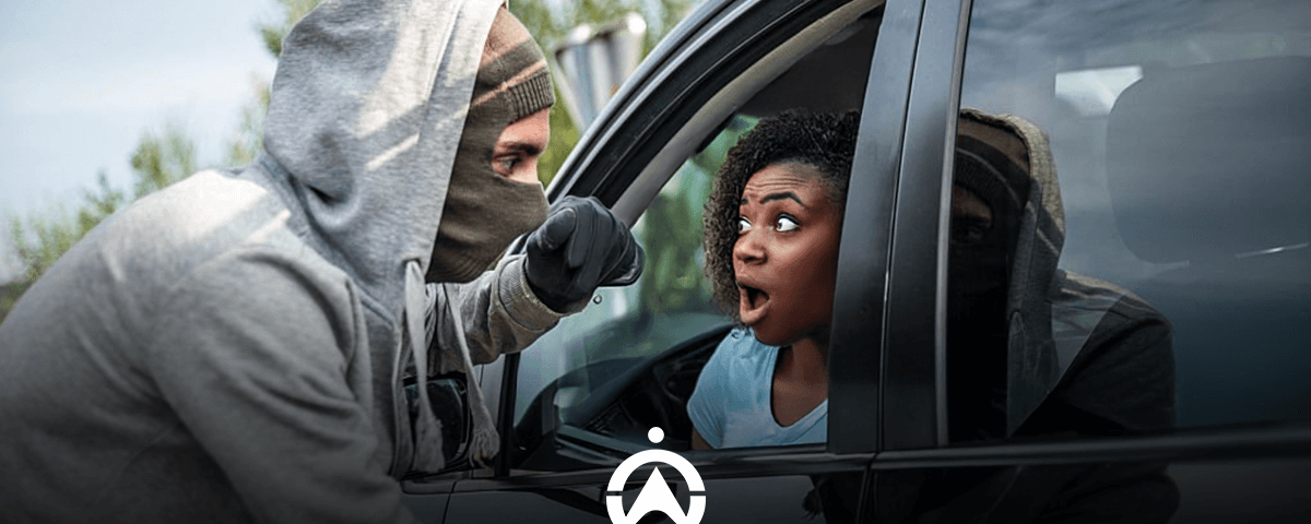 A person in a gray hoodie leans into a car window, appearing to confront the driver inside the vehicle.
