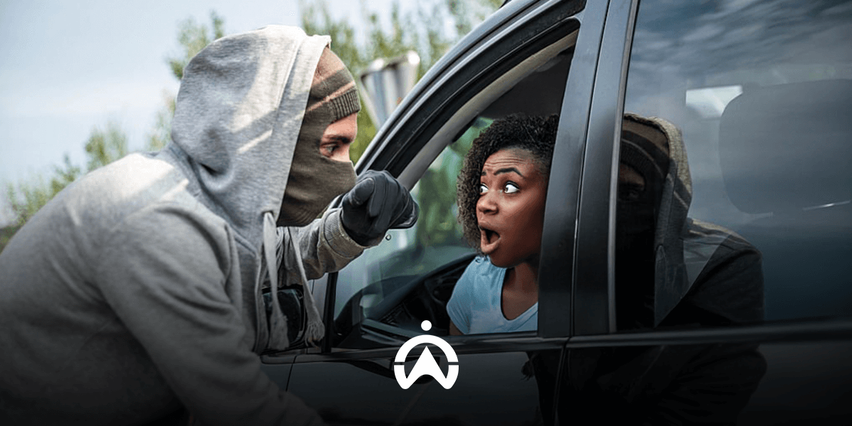 A person in a gray hoodie leans into a car window, appearing to confront the driver inside the vehicle.