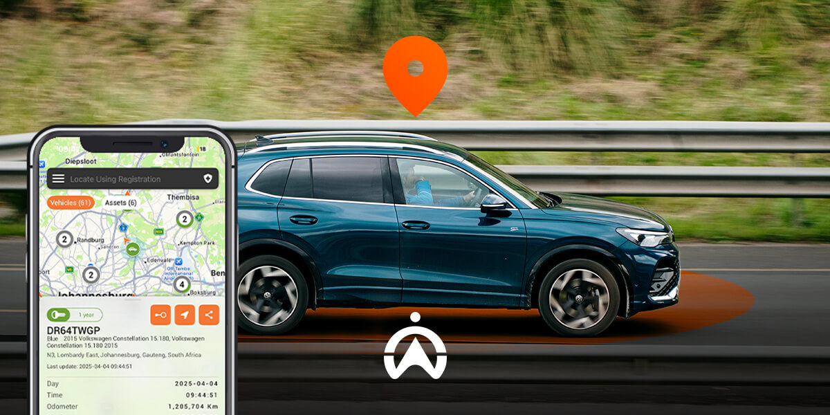 A blue Volkswagen SUV drives past a highway railing, with a smartphone displaying a vehicle tracking map and location pin.