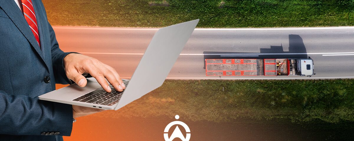 A businessman in a suit uses a laptop while an aerial view shows a truck driving on a highway surrounded by greenery.