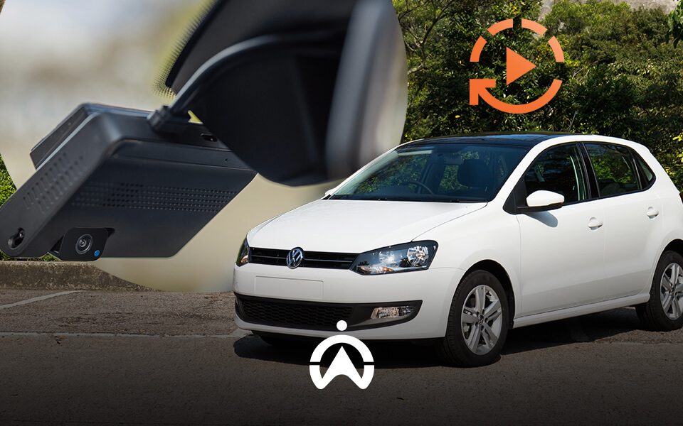 A white Volkswagen Polo parked, with a close-up of a dashcam and a play icon superimposed, suggesting video recording feature.