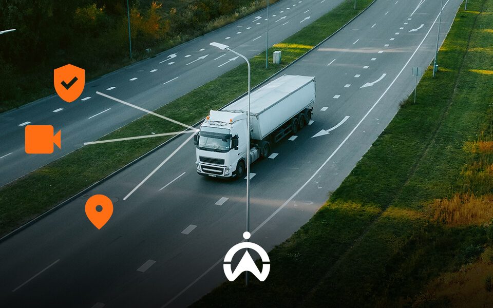 A white truck drives on a highway with icons representing video, location, and safety monitoring above it.