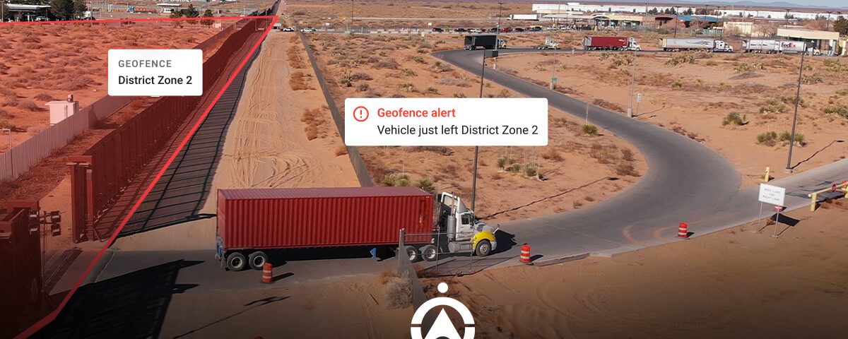A truck leaves a designated geofenced area labeled 'District Zone 2,' with a warning alert displayed on the screen.