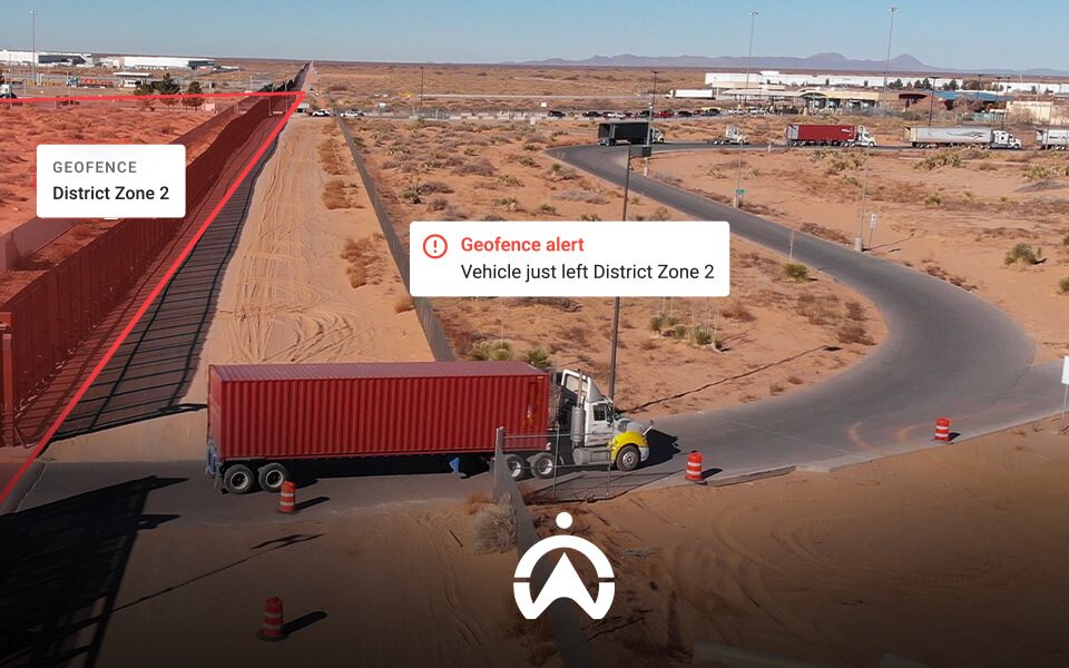 A truck leaves a designated geofenced area labeled 'District Zone 2,' with a warning alert displayed on the screen.