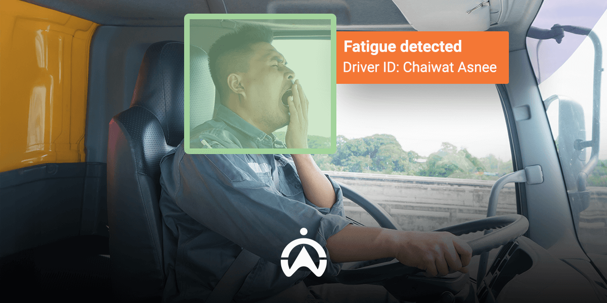 A truck driver sits in the cabin, with alert signs indicating detected fatigue, emphasizing safety on the road.