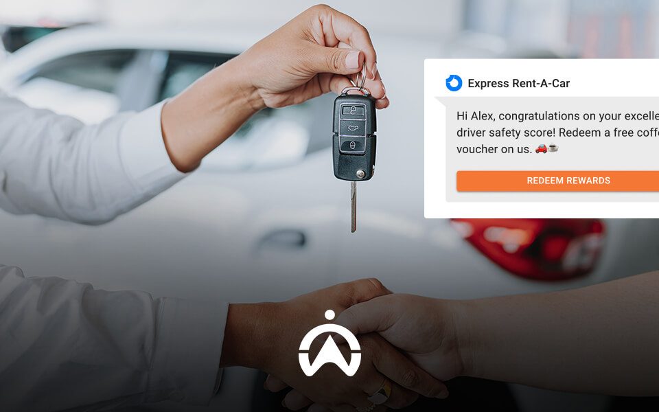 A hand is receiving car keys with a notification congratulating a driver on their safety score and offering a coffee voucher.