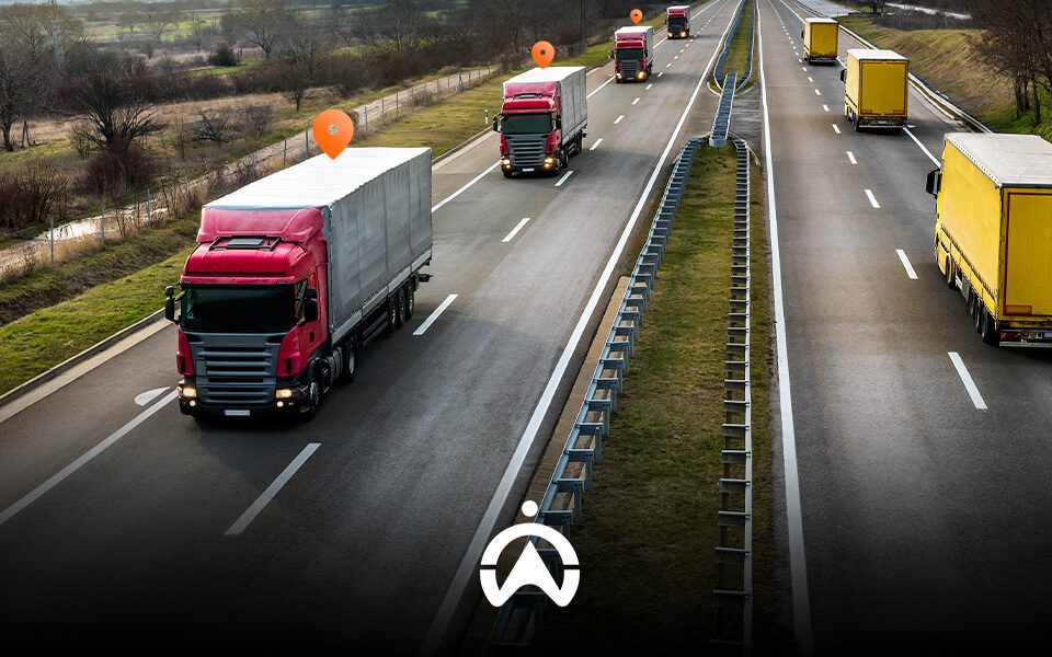 A busy highway with multiple trucks, including red and yellow ones, and location markers indicating tracking points.
