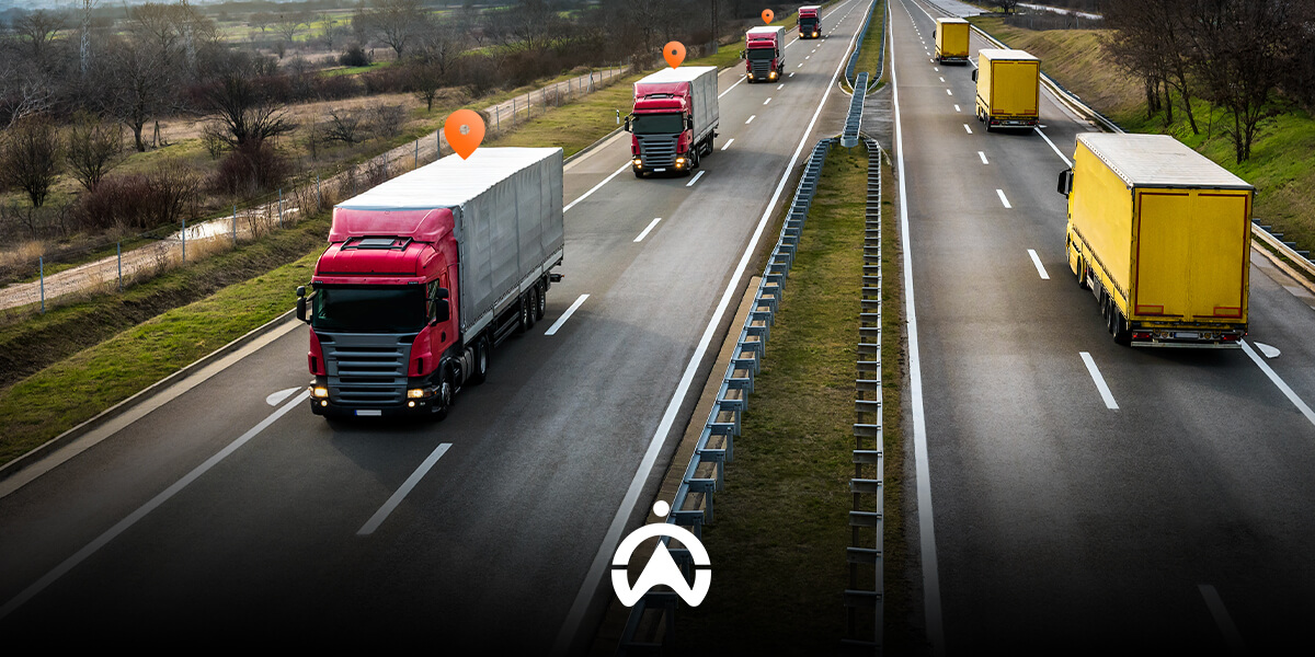 A busy highway with multiple trucks, including red and yellow ones, and location markers indicating tracking points.